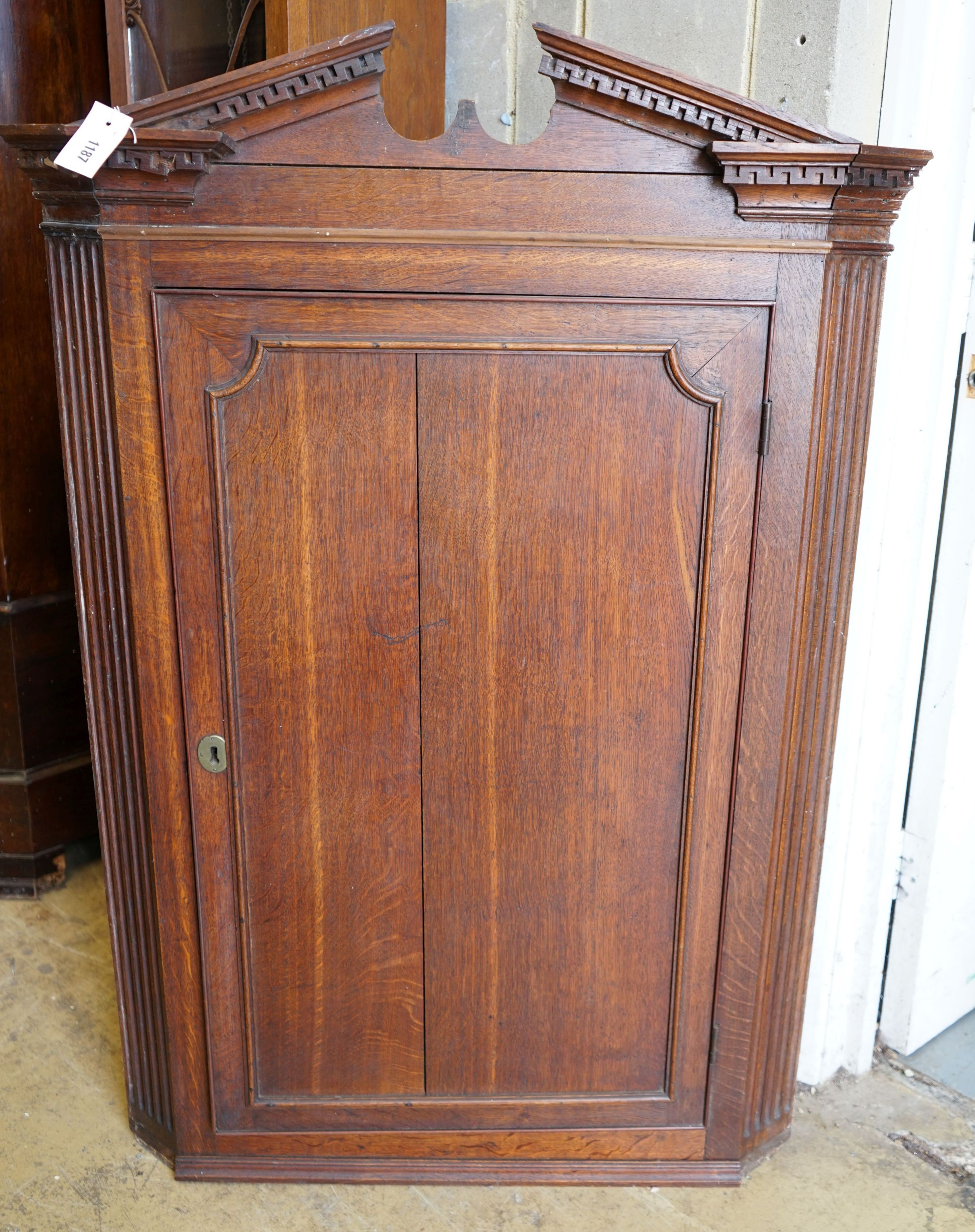 A George III oak hanging corner cabinet, width 85cm, depth 47cm, height 127cm